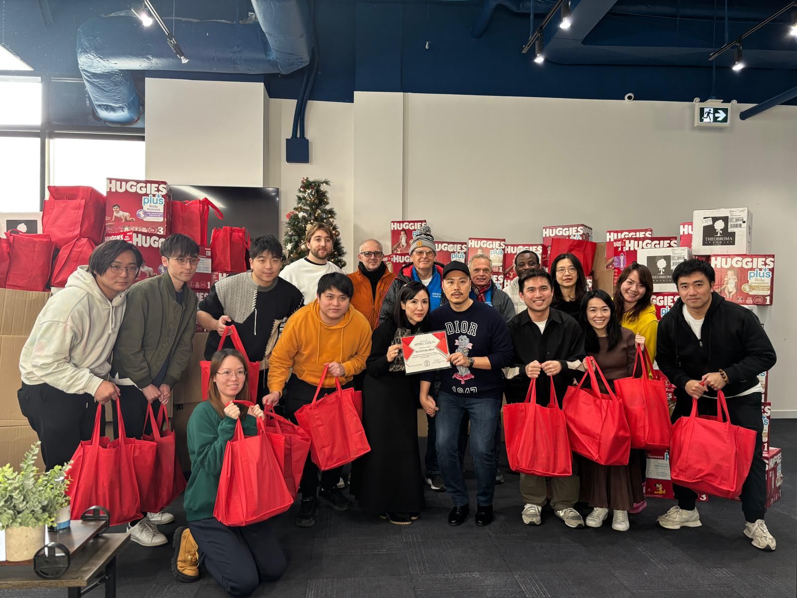 A local business team holding filled red bags at their office